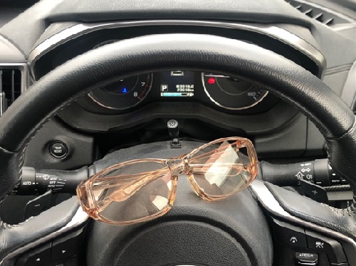 自動車のハンドルの上に乗せたナールスのメガネ