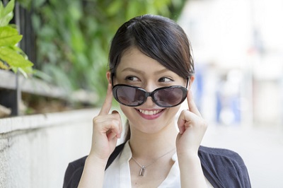 紫外線をカットするためサングラスをかける女性